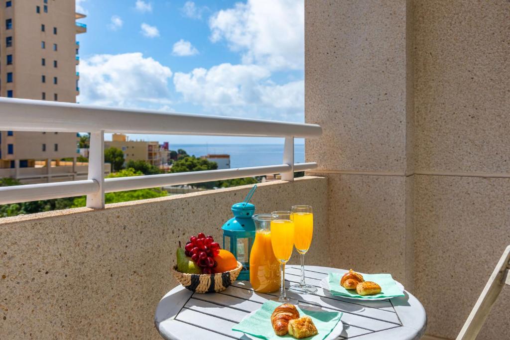 a table with food and drinks on a balcony at Apartment Happy - PlusHolidays in Calpe