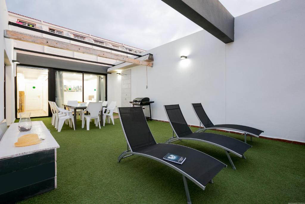 a room with chairs and a dining room with green carpet at Luxury Apartment in Adeje