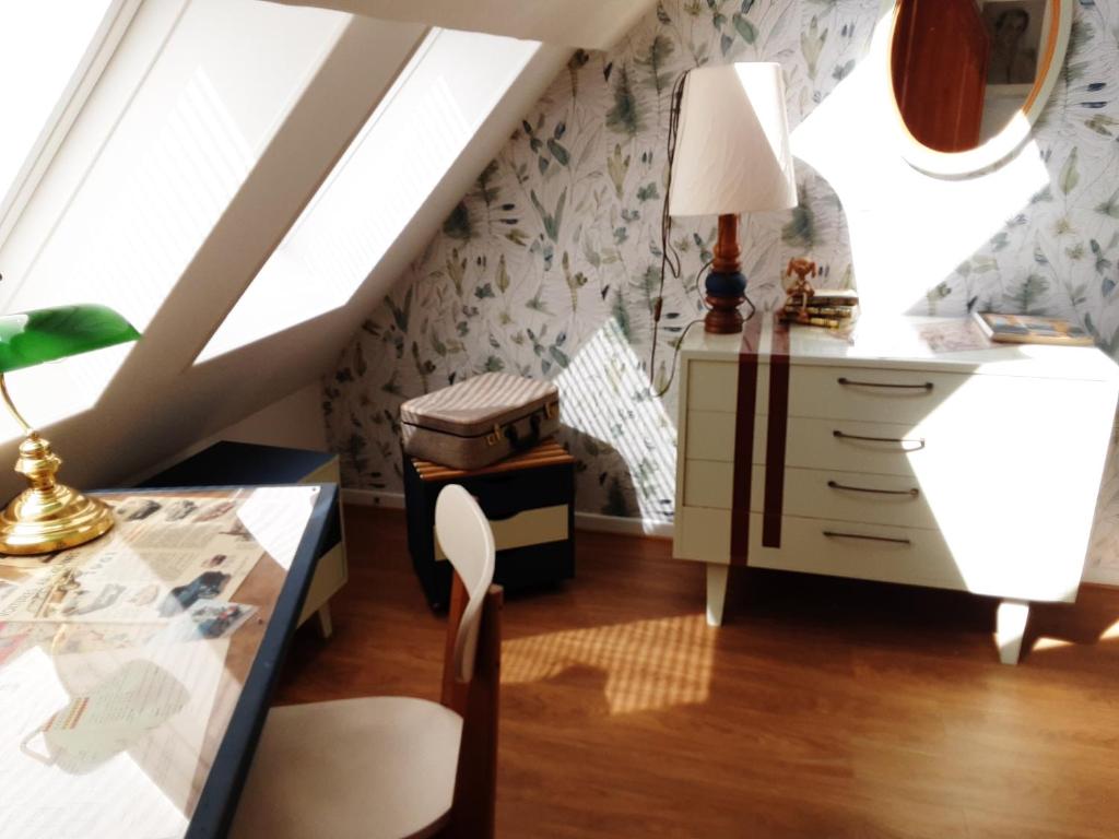 a room with a desk and a table with a lamp at Le Clos du Buisson in Saint-Julien-de-la-Liègue