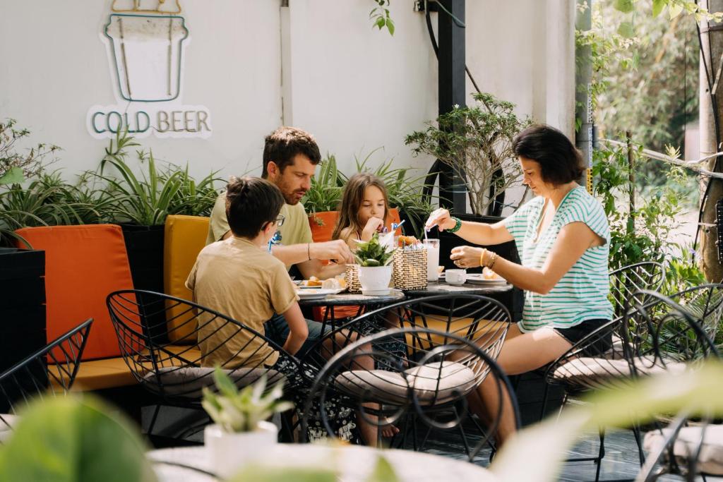 een groep mensen die aan een tafel in een restaurant zitten bij Haemer Villa Green Hearth Stay in Hội An