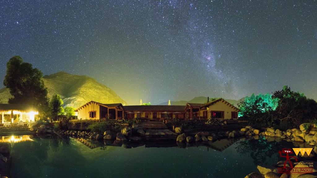 a starry night with a house and the milky way at Hotel Boutique Refugio El Molle in El Molle