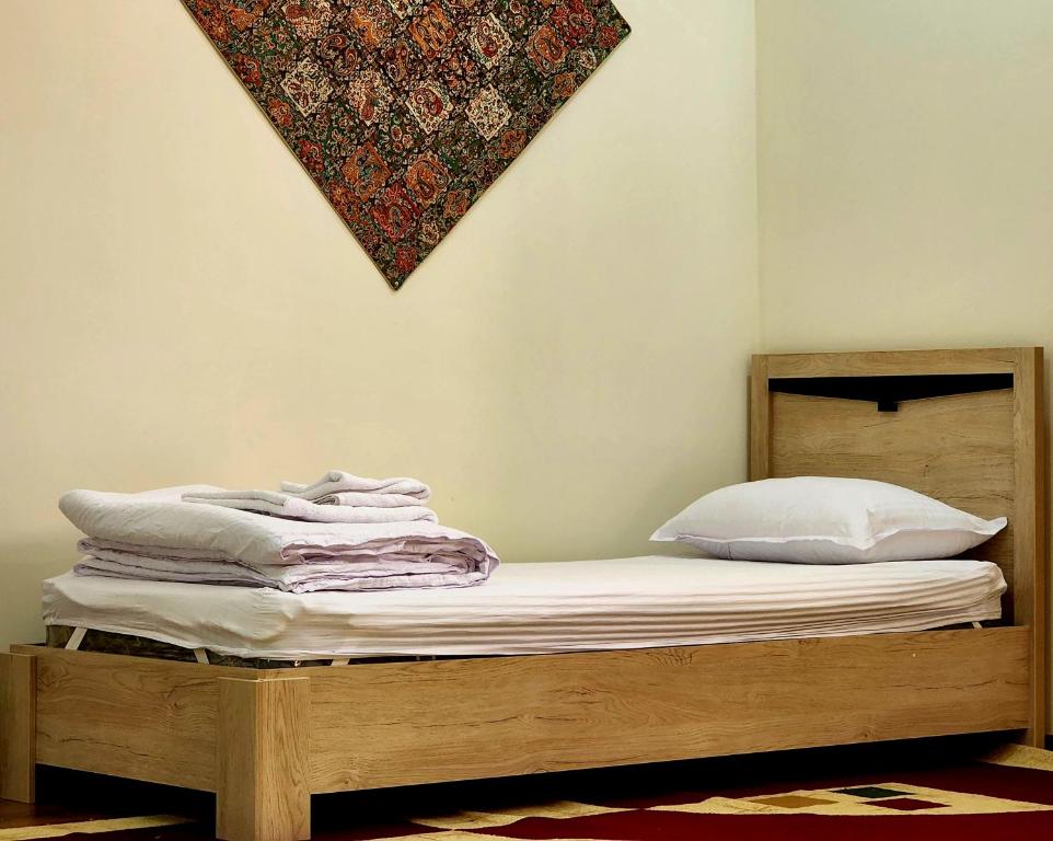 a bed with white sheets and pillows on it at Donish Hotel in Bukhara