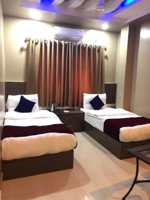 a bedroom with two beds and a window at Hotel Span in Butwāl
