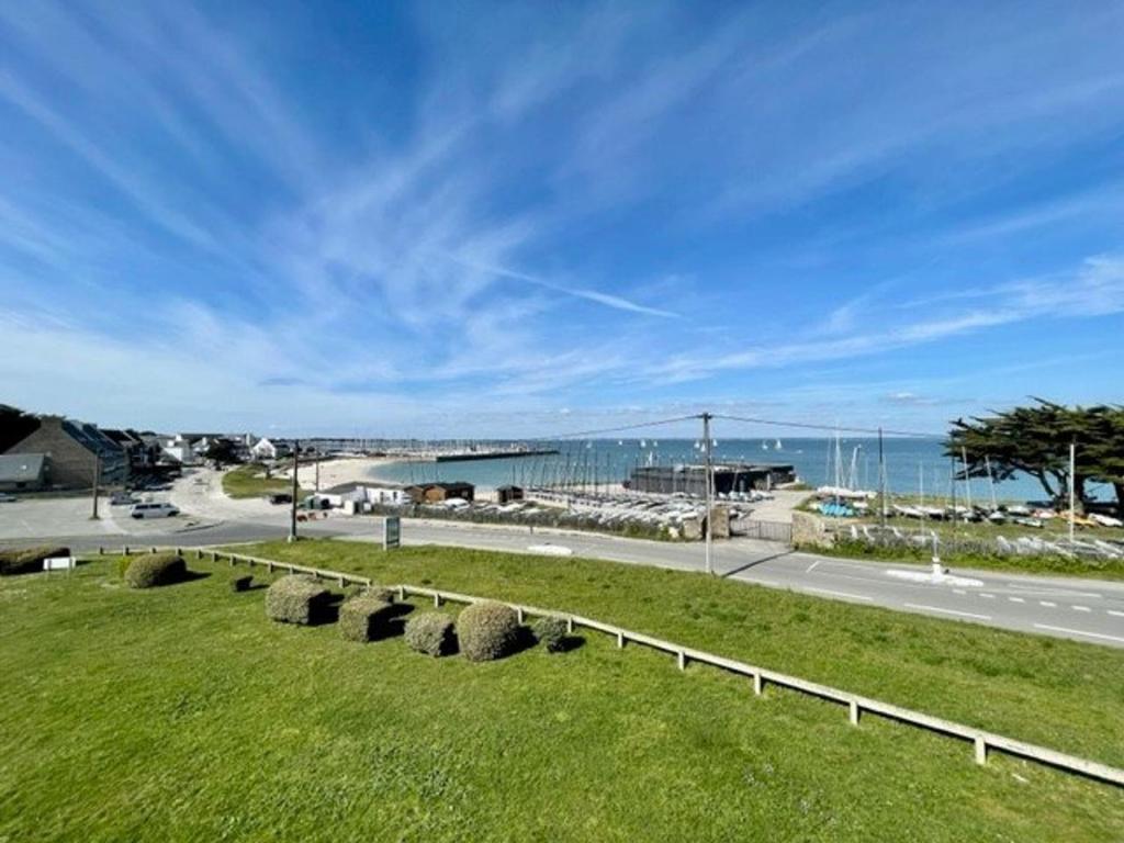 un champ d'herbe avec une clôture et l'océan dans l'établissement Studio mezzanine à Quiberon - 4 pers, 2 balcons, parking, animaux acceptés - FR-1-478-67, à Quiberon