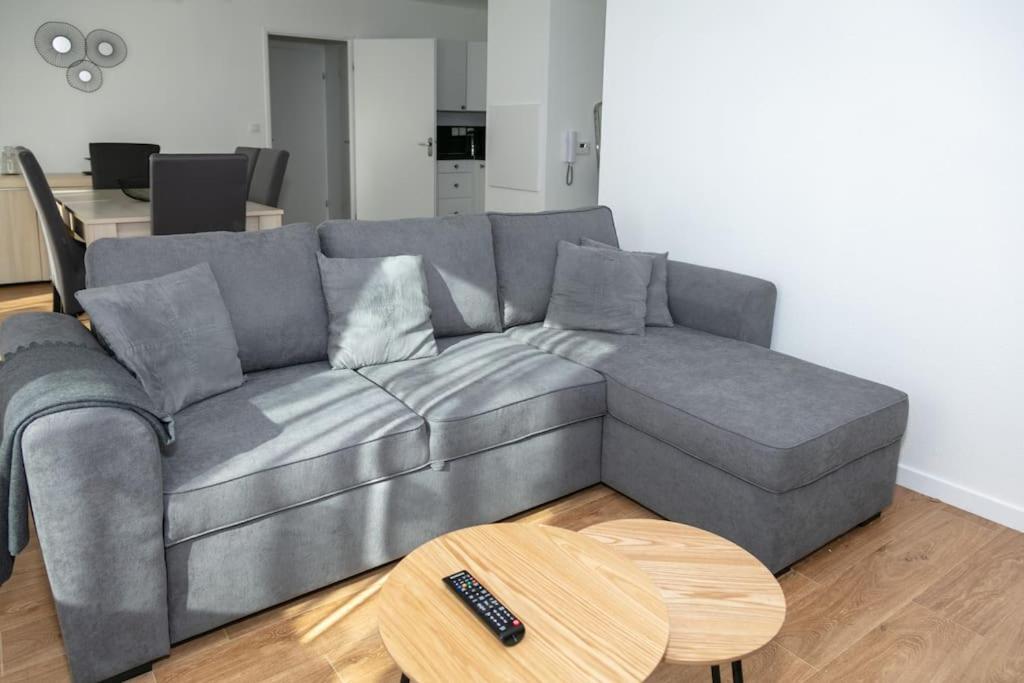 a gray couch in a living room with a table at appartement vacances en copropriété avec parking in Saint Malo