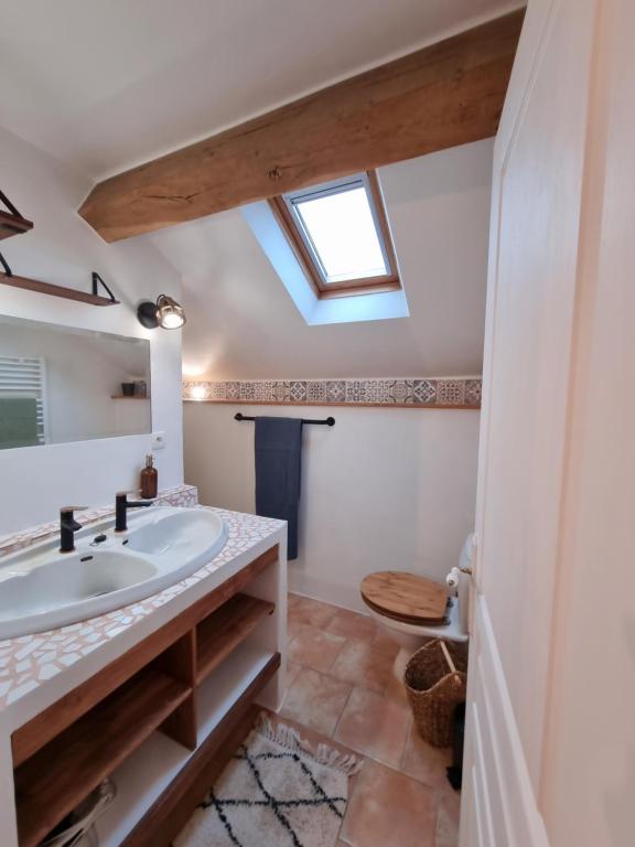 a bathroom with a sink and a skylight at La Ferme de Philomène - Gîte en Périgord Noir in Sainte-Foy-de-Belvès