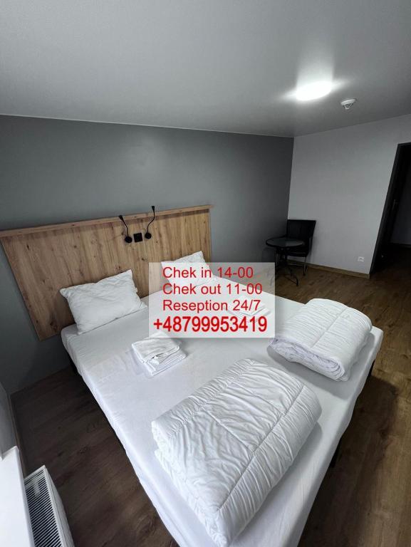 Una cama grande en una habitación con un cartel. en FOKA Hostel, en Wroclaw