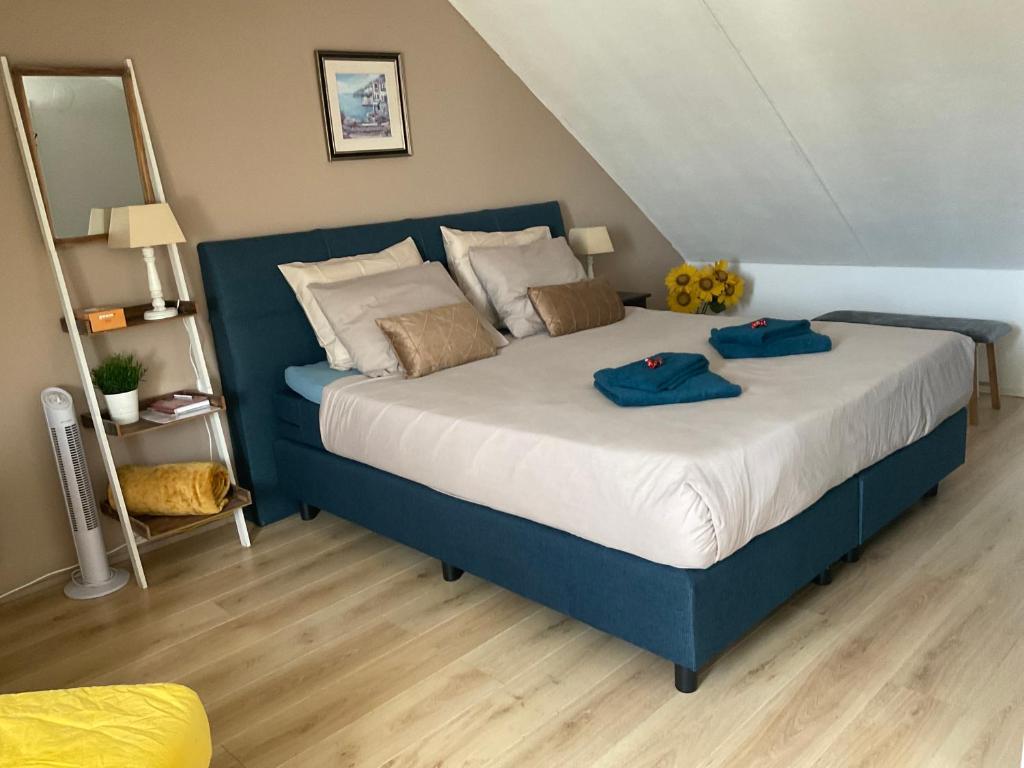 1 dormitorio con 1 cama con 2 toallas azules en B&B Holiday-44, en Enkhuizen