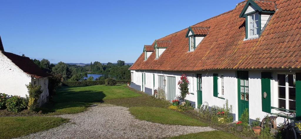 Casa blanca con techo rojo en Chambres d'hôtes B&B Cote d'Opale La Fermette du Lac, en Ardres
