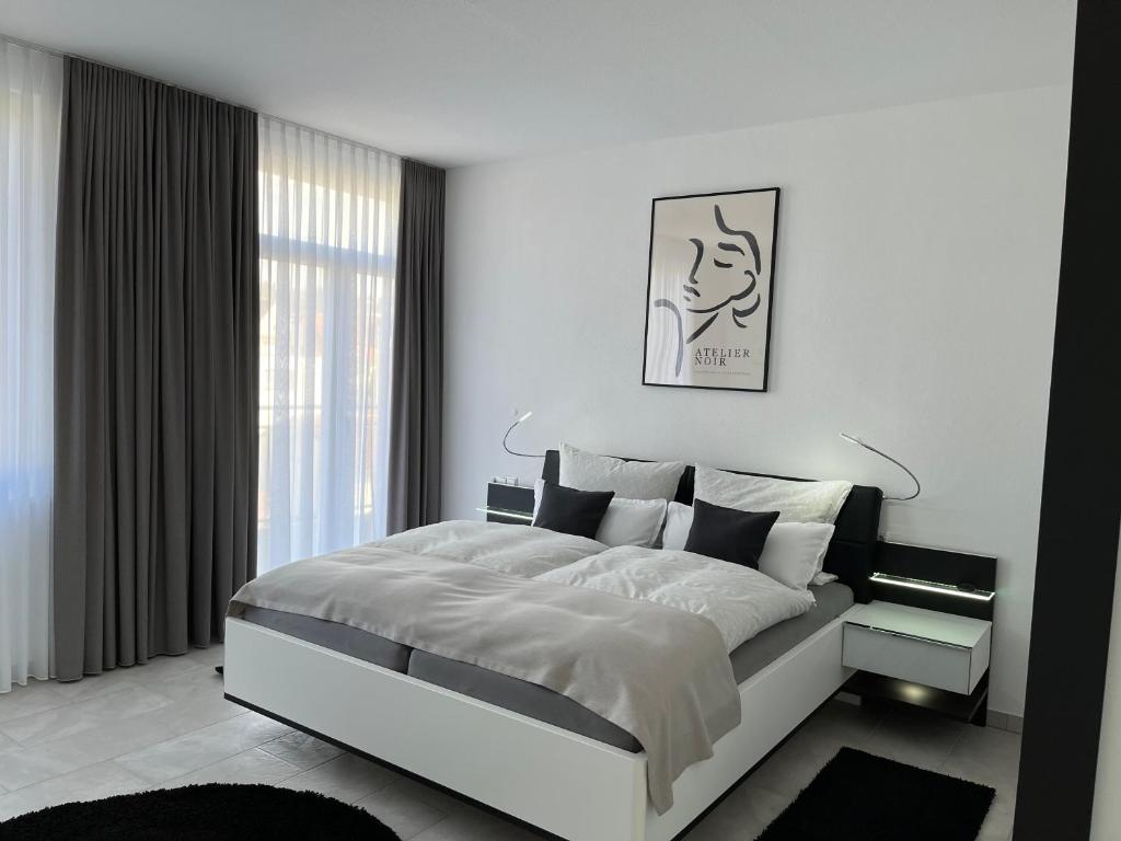 een witte slaapkamer met een groot bed en een raam bij Zollernalbdomizil FeWo2 in Balingen