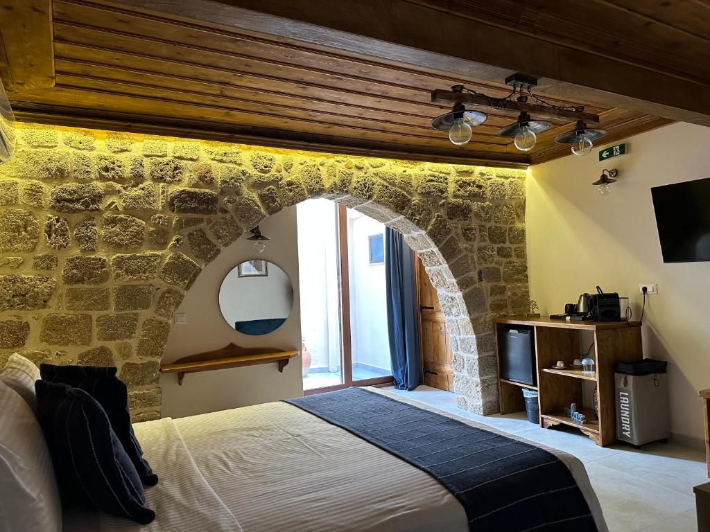 um quarto com uma parede de pedra e uma cama em Midgard Suites (Medieval Town) in Ilha de Rhodes