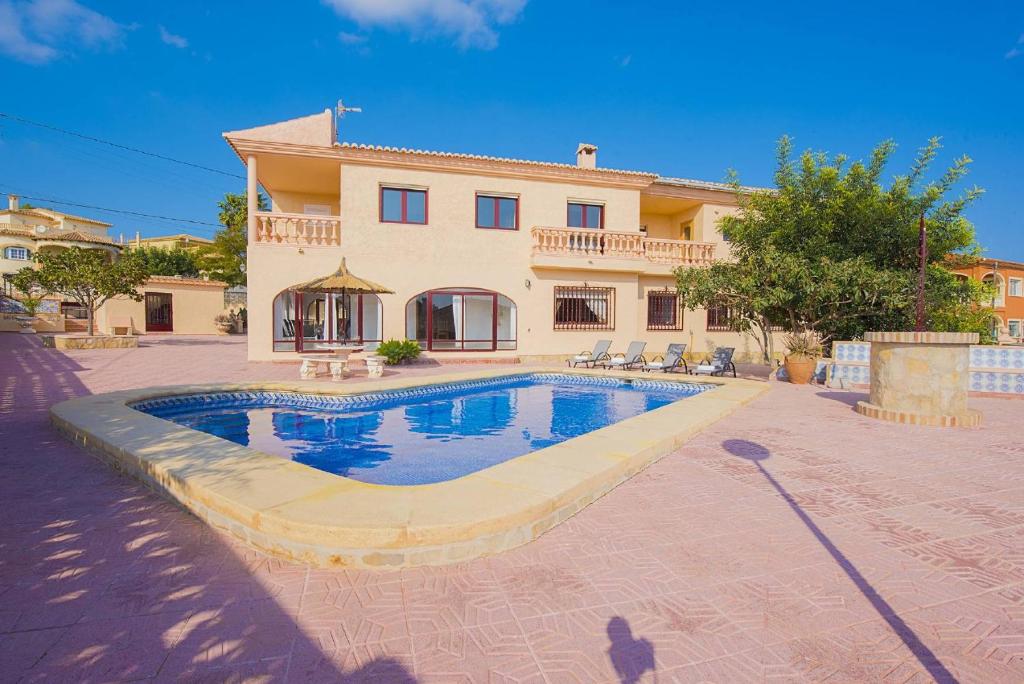 a house with a swimming pool in front of it at Villa Lina - PlusHolidays in Calpe