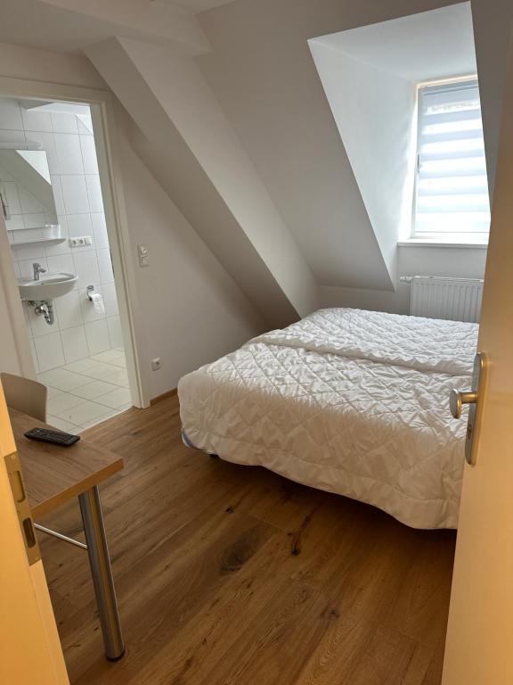 een slaapkamer met een bed en een badkamer met een wastafel bij Alter Wirt Ramersdorf in München