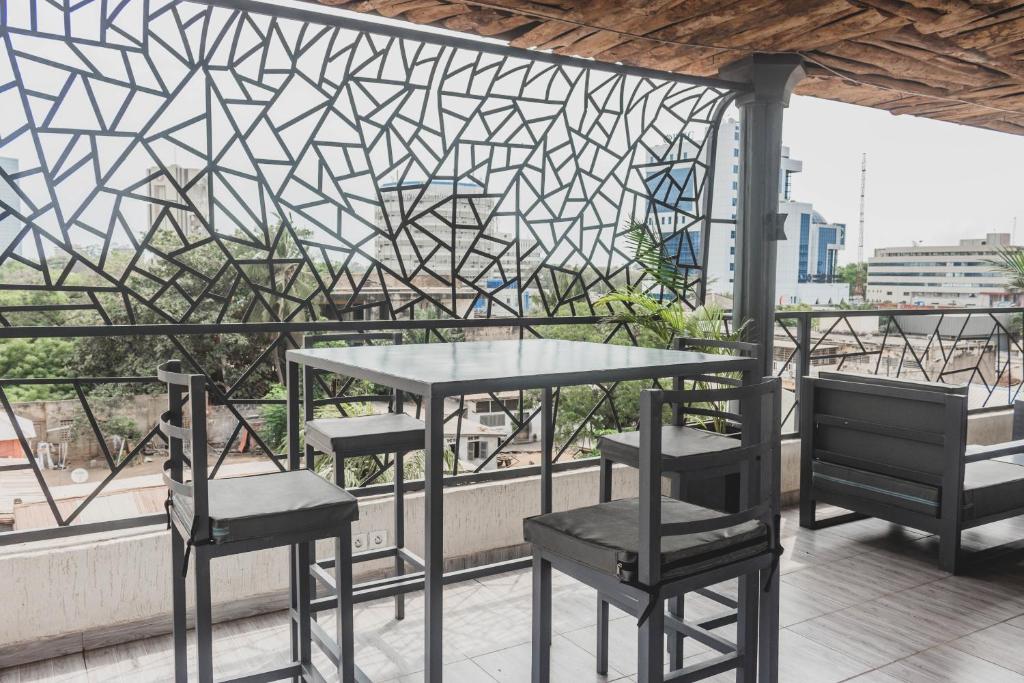a table and chairs on a balcony with a view at Les perles du bonheur Nyékonakpoé in Lomé