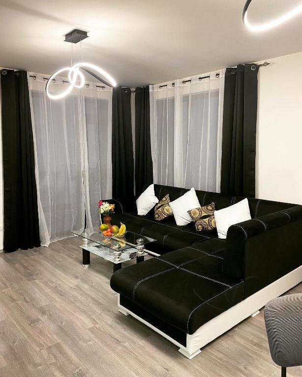 a living room with a black couch and a table at Casa.Puf in Techirghiol