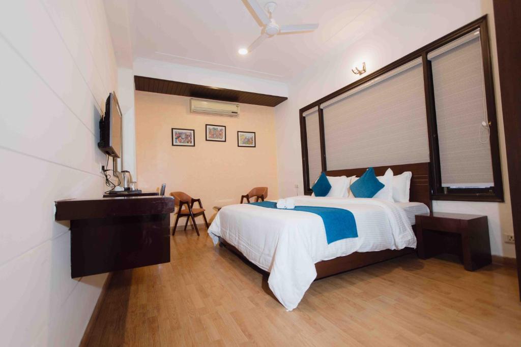 a bedroom with a bed and a desk and a television at Plaza Residency in Gurgaon