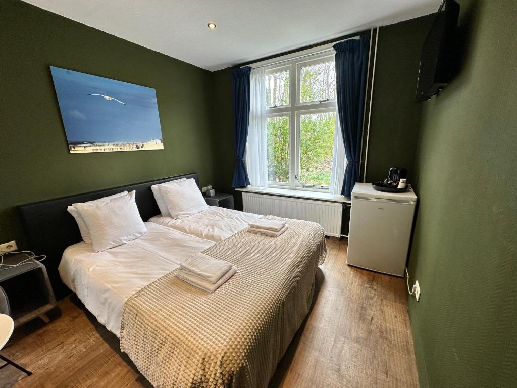 een kleine slaapkamer met een bed en een raam bij Hotel Huys ter Schelde in Koudekerke