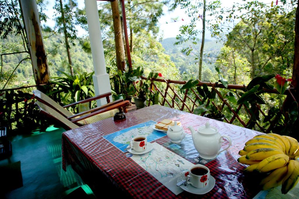 a table with two cups of coffee and bananas on it at " YOLO " LOVELY COTTAGE in Ella