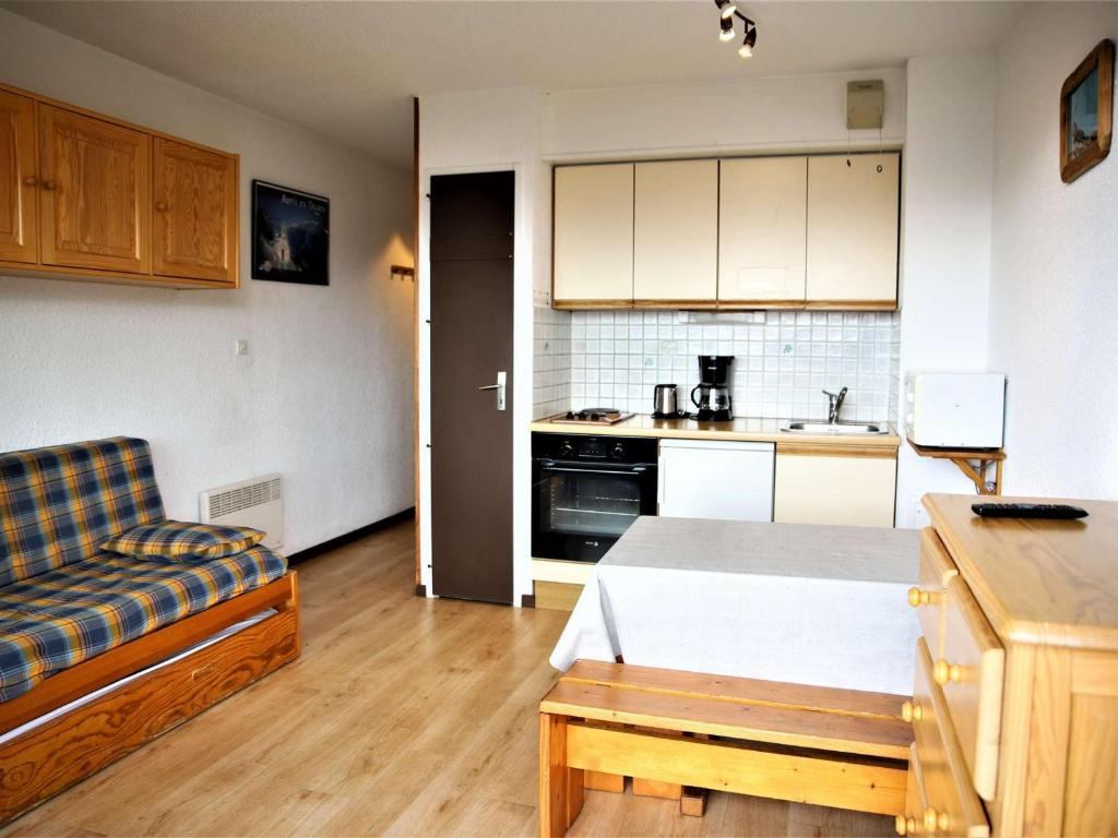 ein Wohnzimmer mit einem Sofa und einer Küche in der Unterkunft Appartement Auris, 1 pièce, 4 personnes - FR-1-297-306 in Auris