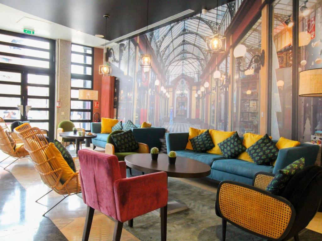 vestíbulo con sofá, mesas y sillas en ibis Styles Evry Courcouronnes Hotel and Events, en Courcouronnes