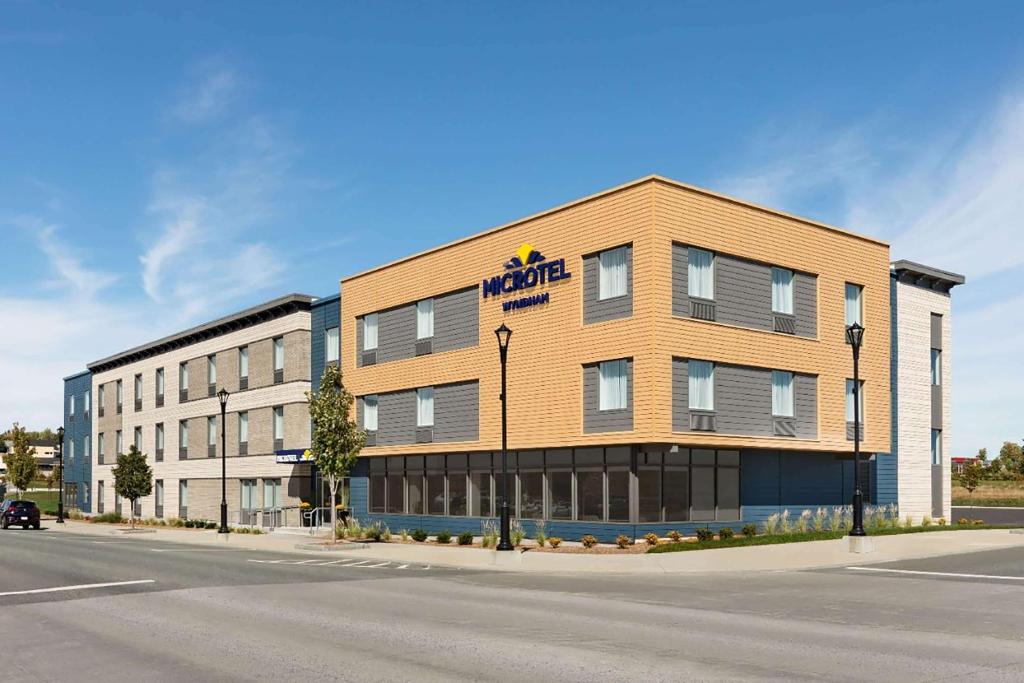 a rendering of a hotel on the corner of a street at Microtel Inn & Suites by Wyndham Lachute in Lachute