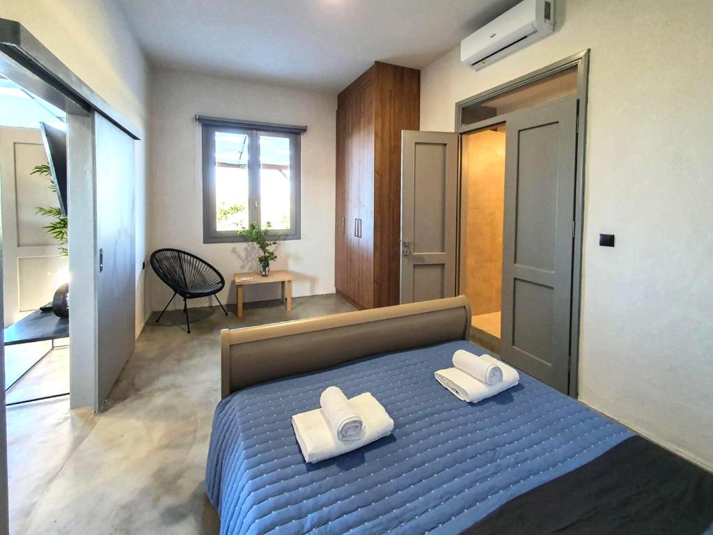 sypialnia z niebieskim łóżkiem i 2 ręcznikami w obiekcie Remvi Suite in Chania w mieście Xamoudhokhórion