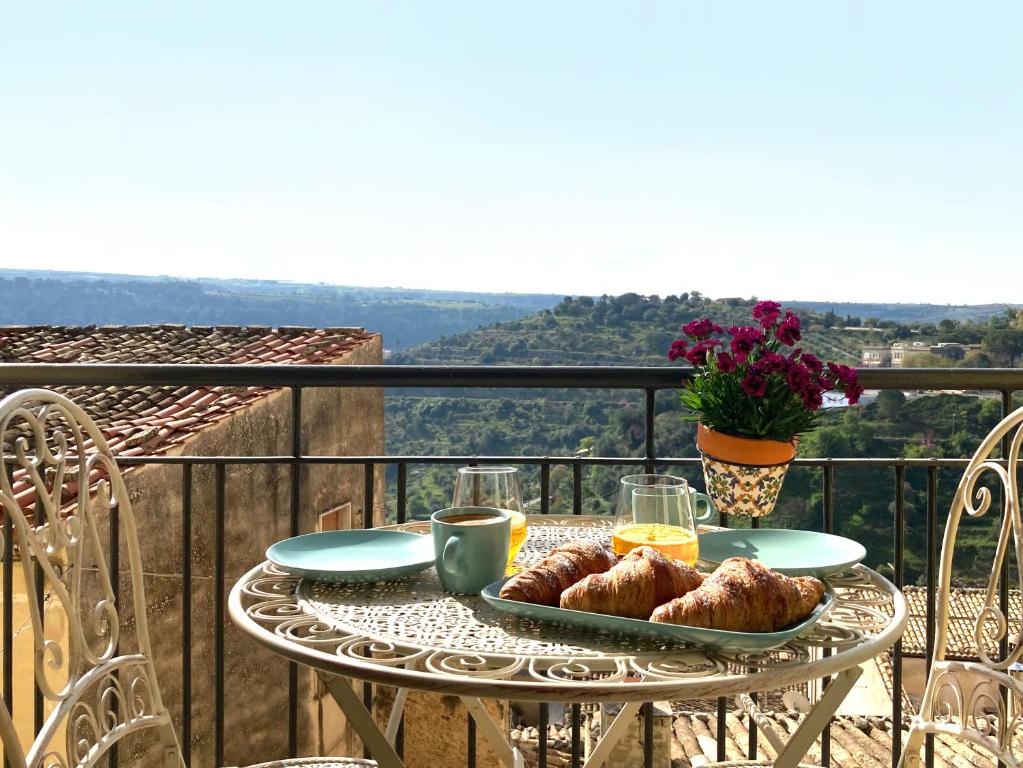 a table with a tray of pastries on a balcony at Casa Alva in Ragusa