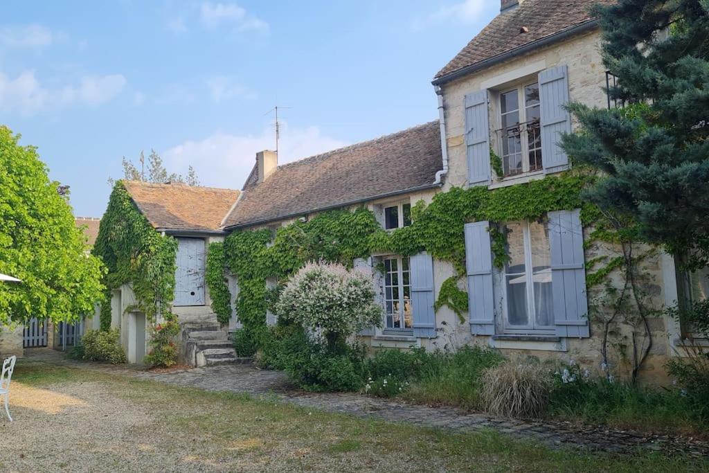 uma casa velha com hera ao lado em L'Angelus de Villiers, belle suite dans corps de ferme em Villiers-sous-Grez