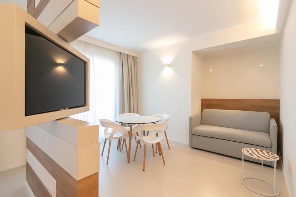 a living room with a television and a table and chairs at Hotel Mistral in Termoli