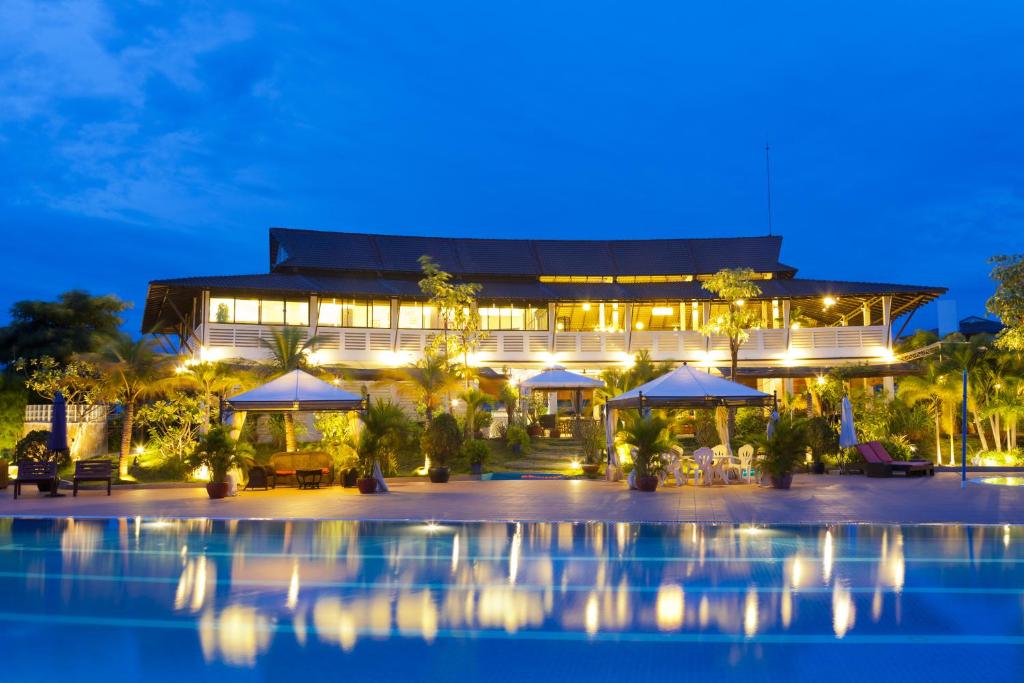 un complexe avec une piscine ouverte la nuit dans l'établissement Cambodian Country Club, à Phnom Penh