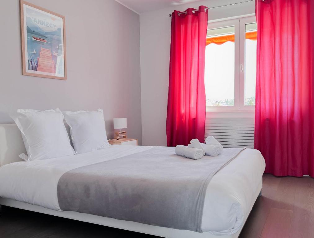 um quarto com uma cama grande e cortinas vermelhas em Penthouse vue incroyable lac et montagnes em Annecy