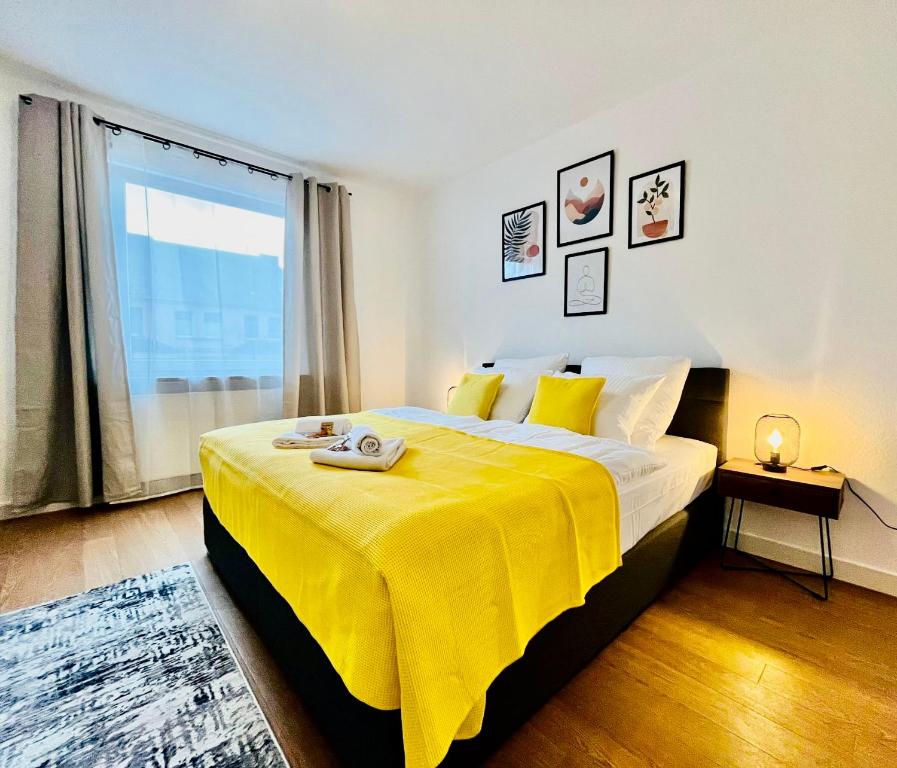 a bedroom with a large bed with a yellow blanket at BIG-6-Guests-Kingsize-Netflix-Badewanne-Hauptbahnhof-Zentral in Koblenz