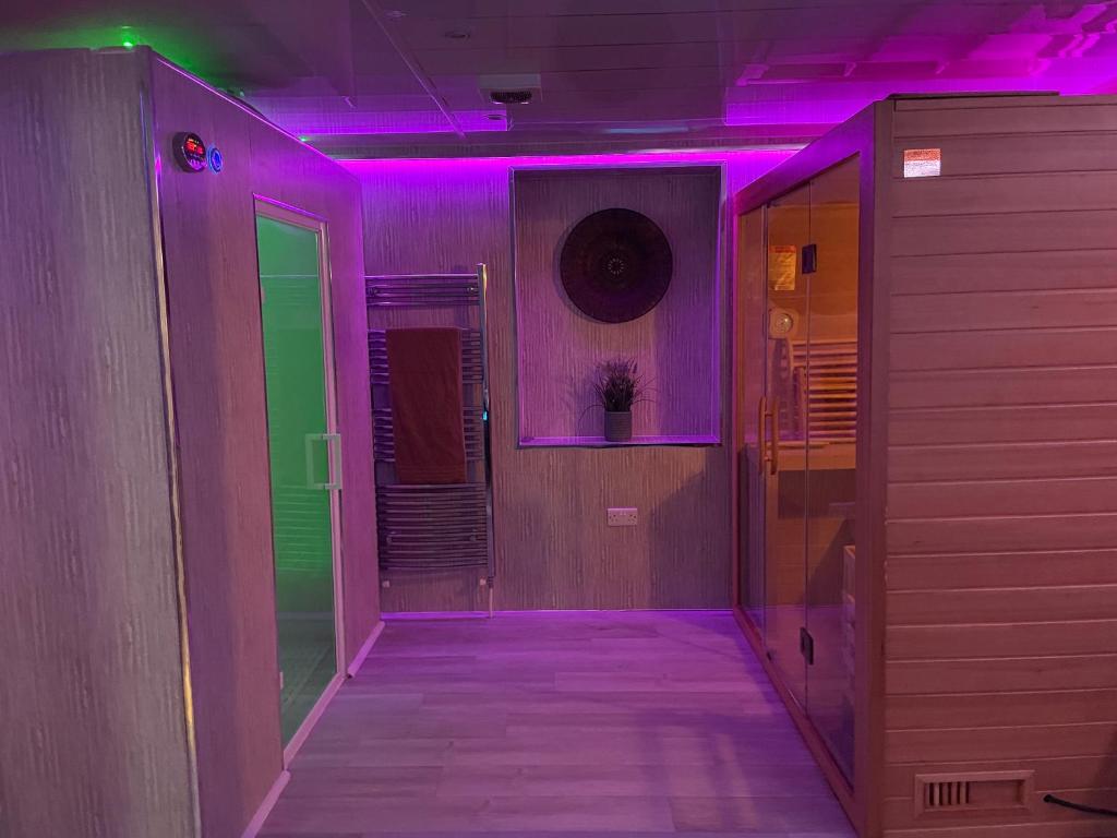 an empty hallway with purple and green lights at Golden Crown exclusive use spa venue in Tarbolton