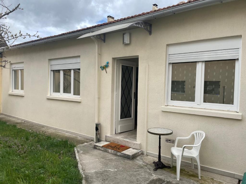 a white chair sitting outside of a house at CALME in Drancy