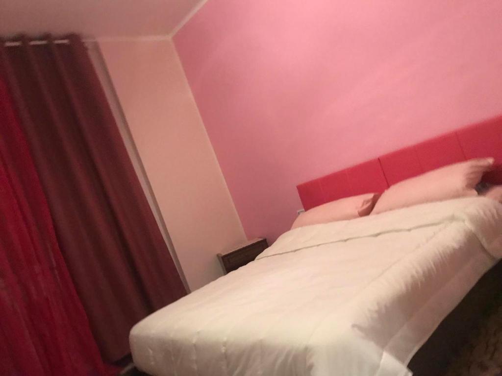 パヴィアにあるB&B Students homeのベッドルーム1室(赤いヘッドボード付きのベッド1台付)