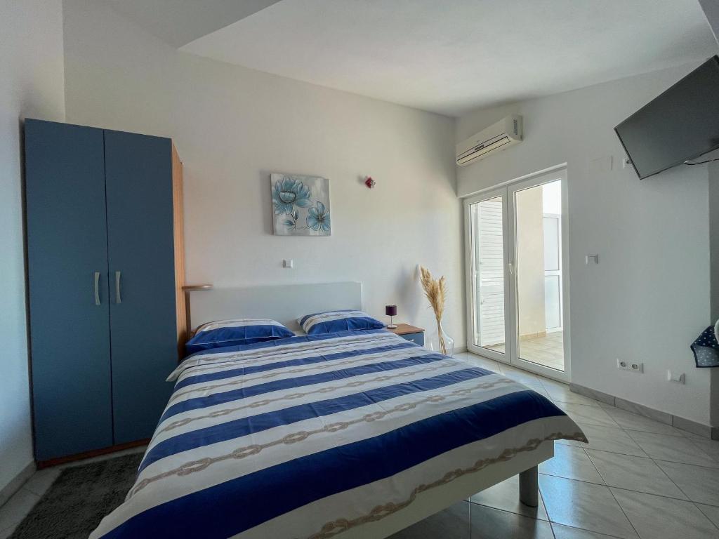 a bedroom with a large bed with a blue cabinet at Apartments Marija Magdalena in Hvar