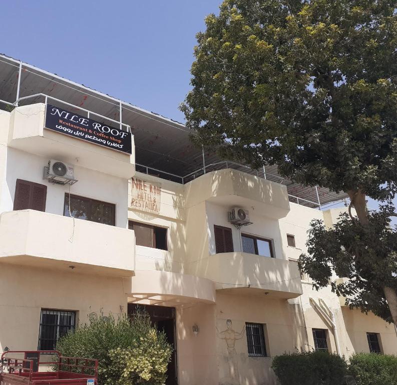 een wit gebouw met een bord aan de zijkant bij Nile Roof Hotel& Restaurant in Luxor