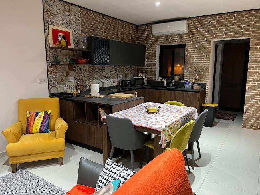 een keuken en eetkamer met een tafel en stoelen bij Duplex Maisonette with roof in Fgura
