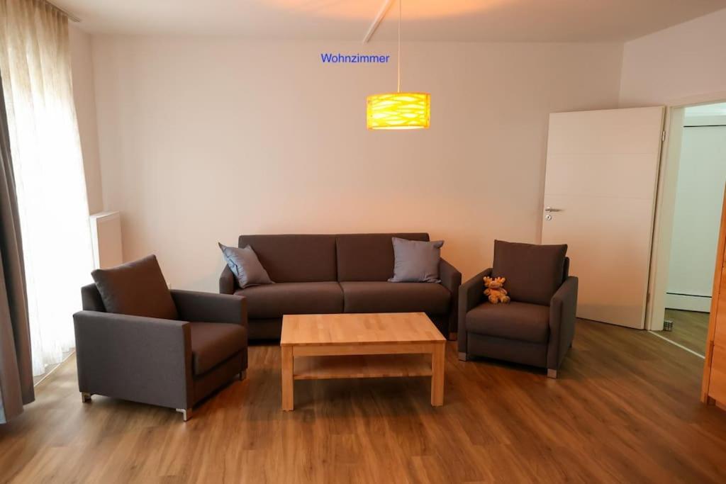 a living room with a couch and two chairs and a table at Freundliche Wohnung mit Parkplatz und Terrasse in Neubrandenburg