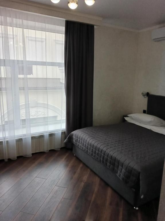 a bedroom with a bed and a large window at Safari-Club in Vinnytsya