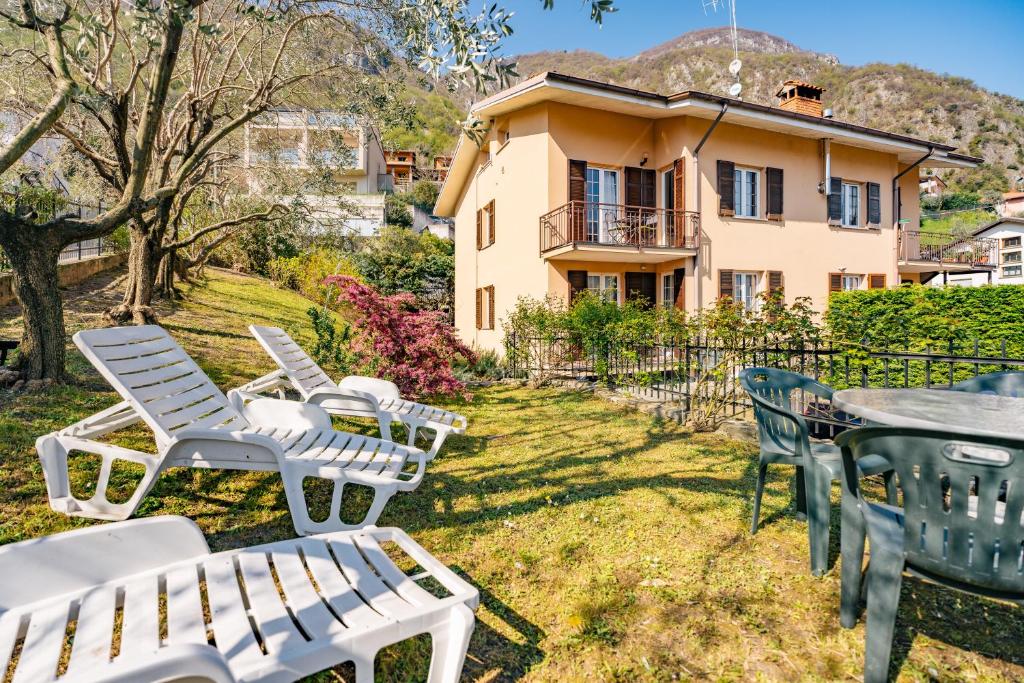 a group of chairs and tables in front of a house at Mary Rose Apartments in Oliveto Lario