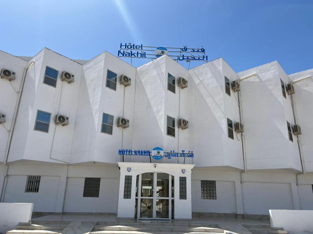 un edificio bianco con un cartello sopra di HOTEL NAKHIL a Nouadhibou