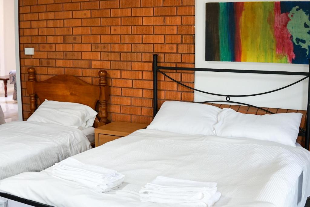 two beds in a room with a painting on the wall at LCF Rosehill Accommodation 3 free car parking inside property G2 in Sydney