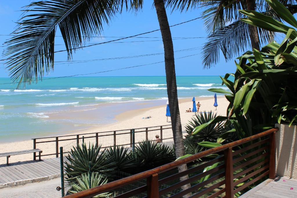 uma vista para a praia a partir da varanda de um resort em Casa Surucuá com localização espetacular frente à Praia do Centro de Pipa - 2 a 4 quartos suite em Pipa