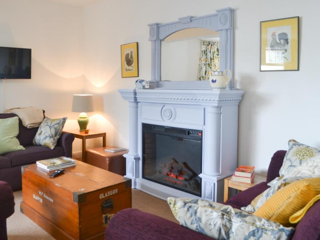 a living room with a fireplace and a couch at The Cottage in Bridlington