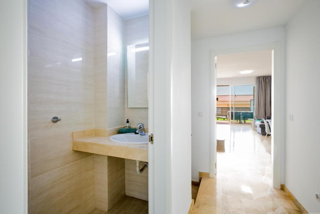 a bathroom with a sink and a mirror at Residencial Playa de La Arena in Puerto de Santiago