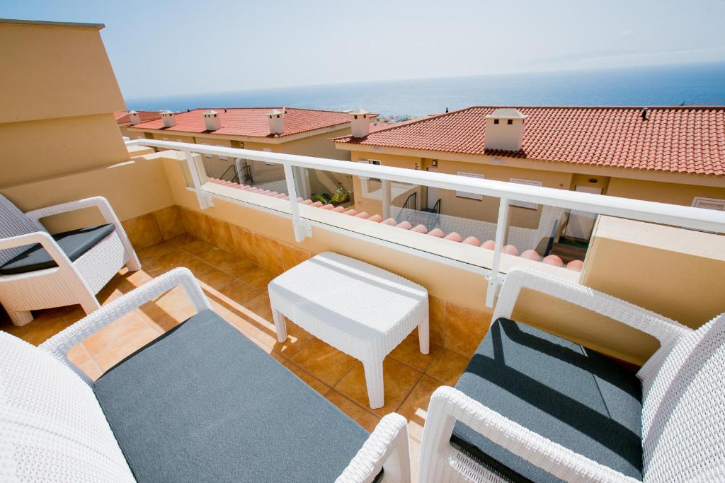 a balcony with chairs and a table and a view of the ocean at Residencial Playa de La Arena in Puerto de Santiago
