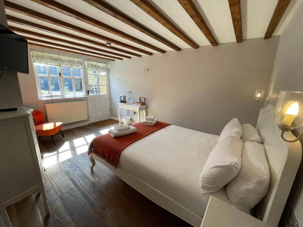 1 dormitorio con 1 cama blanca grande en una habitación en The Queen Matilda Country Rooms en Tetbury