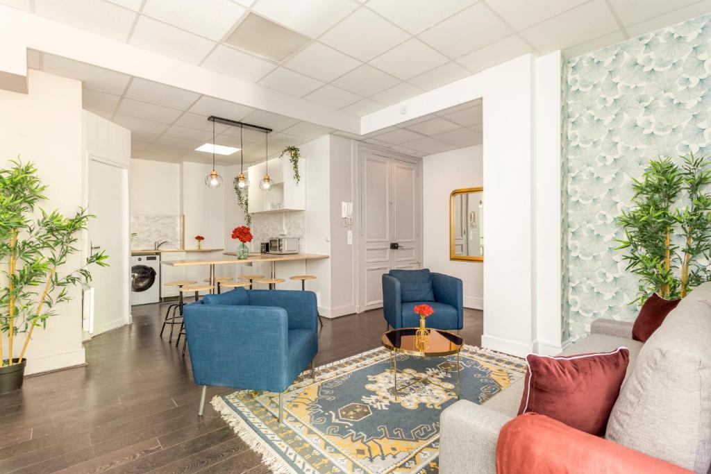 uma sala de estar com cadeiras azuis e uma mesa em Cosy 3 bedrooms apartment with bathrooms - Louvre em Paris