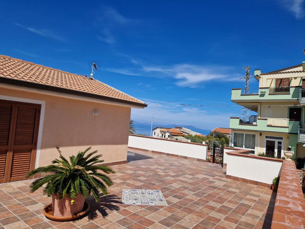 une terrasse dans une maison avec une plante en pot dans l'établissement franci e aurora house, à Capo dʼOrlando